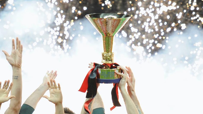 Milan captain Massimo Ambrosini holds aloft the Serie A trophy.