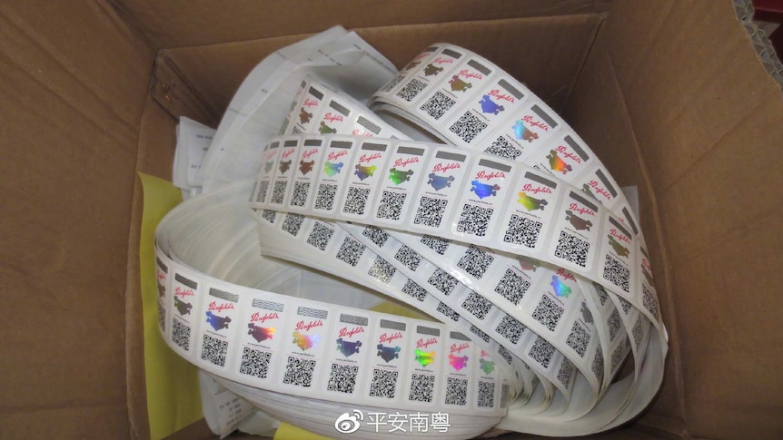 A box filled with a roll of anti-counterfeit labels.