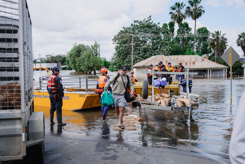 a group of volunteers bring in a boat which has ebenin floodwater