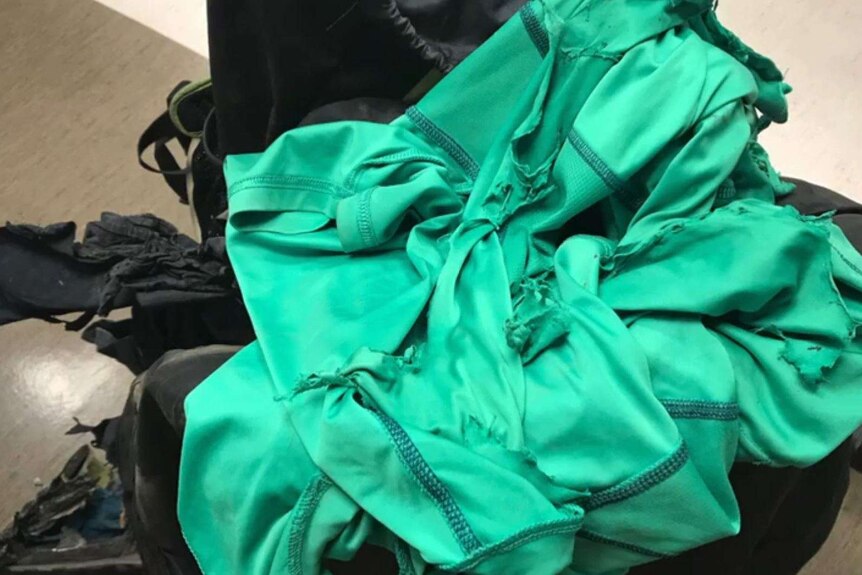green and black hiking clothes are ripped to shreds