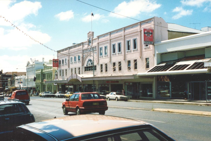 Colour photograph of 1980s main street of a town with old two storey building saying Orange City Centre