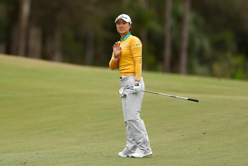 Australian golfer Minjee Lee holds her hand up as she looks down the fairway at the LPGA Tour Championship.