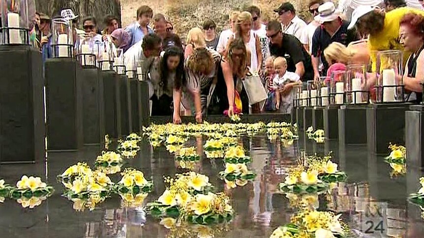 Flowers are placed in the water at the memorial service in Bali today