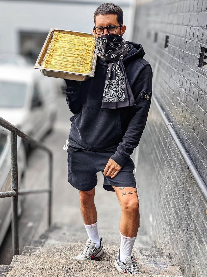 A man carrying a tray of pasta