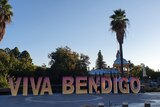 'VIVA BENDIGO' cut out signs in pink to yellow balayage on display in Rosalind Park, Bendigo