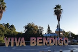 'VIVA BENDIGO' cut out signs in pink to yellow balayage on display in Rosalind Park, Bendigo