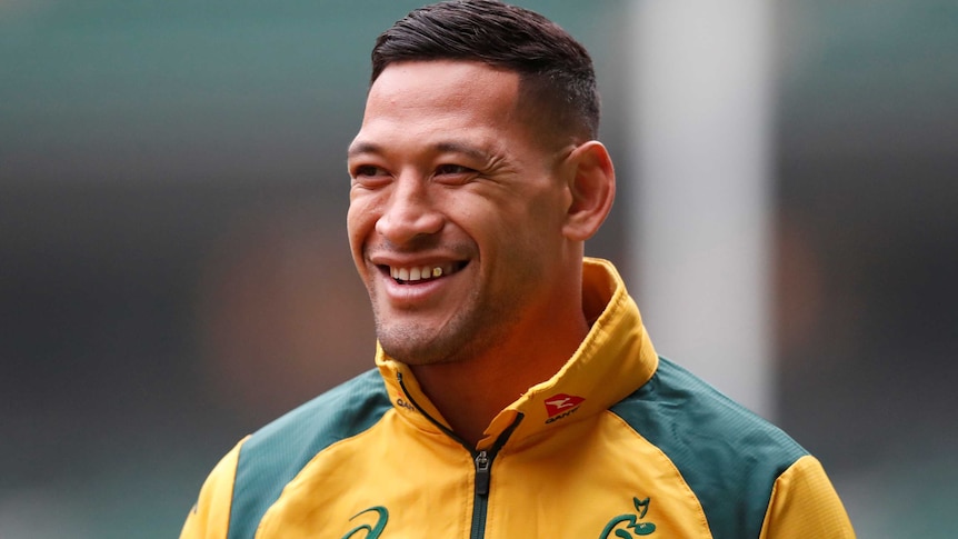 Israel Folau in a Wallabies jacket smiles at someone off camera