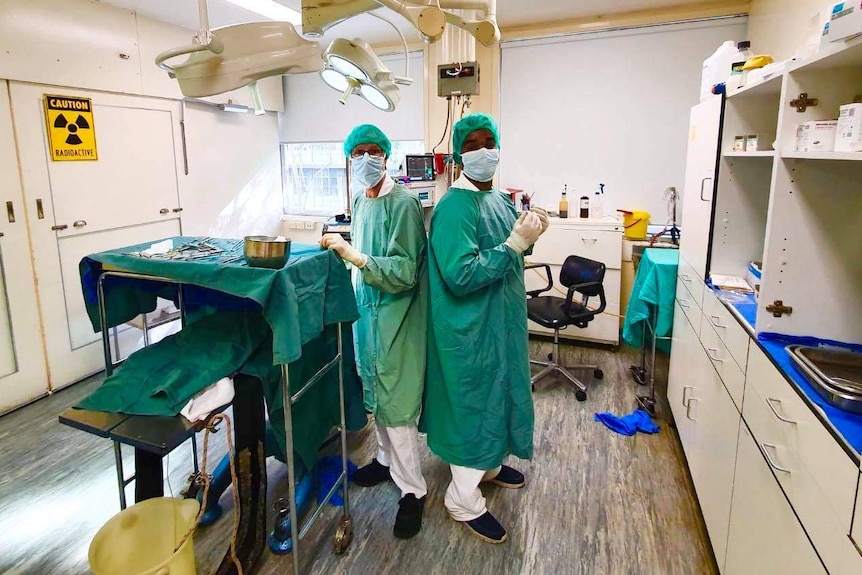 Researchers Dr Yugeesh Lankadeva and Professor Clive May stand back to back in an operating theatre.
