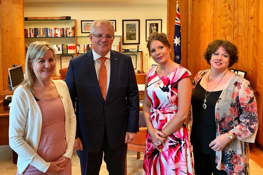 Trois femmes avec Scott Morrison dans un bureau.