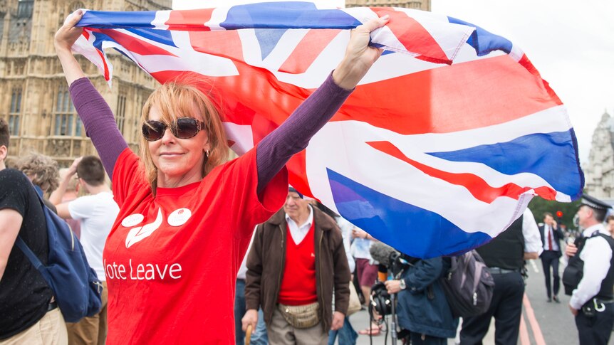 A woman waves a Union Jack in front of the British parliament in London.