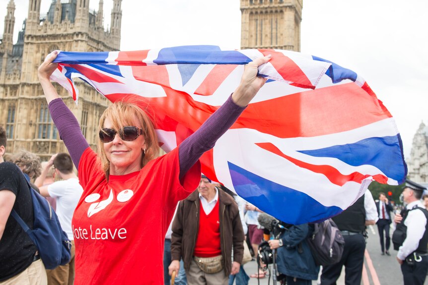 A woman waves a Union Jack in front of the British parliament in London.