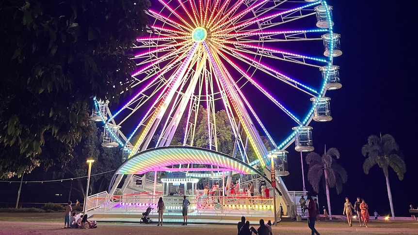A colourful ferris wheel lit up at night