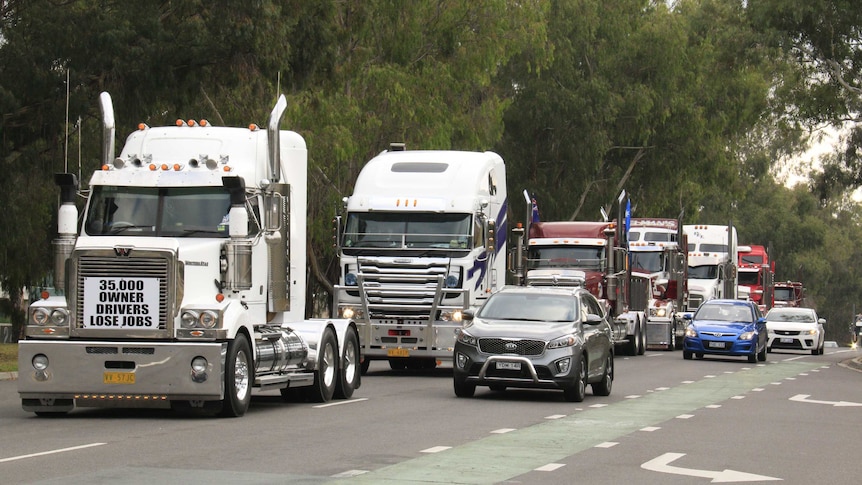 Trucks honk their horns on their way to Parliament House this morning.