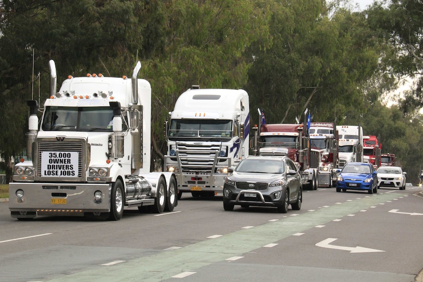 Trucks honk their horns on their way to Parliament House this morning.