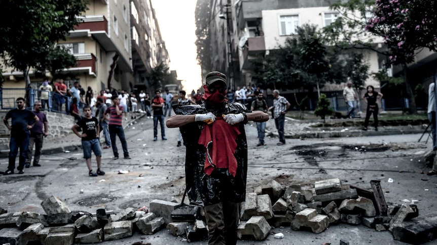 Left-wing protesters gather near a barricade during clashes with Turkish riot police in the district of Gazi in Istanbul