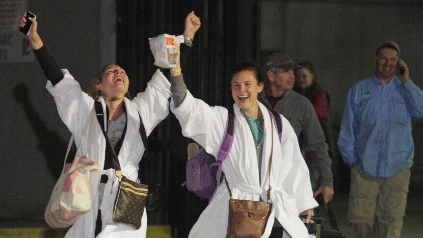 Kendall Jenkins (left) and a friend cheer after stepping off the crippled Carnival ship Triumph in Mobile, Alabama.