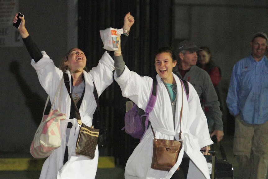 Kendall Jenkins (left) and a friend cheer after stepping off the crippled Carnival ship Triumph in Mobile, Alabama.