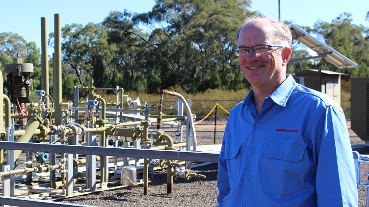 Santos vice president Bruce Clement standing in front of a gas well in the Pilliga forest in NSW.