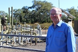 Santos vice president Bruce Clement standing in front of a gas well in the Pilliga forest in NSW.