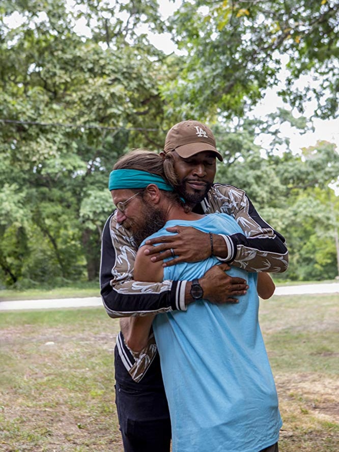 Karamo Brown closes his eyes as he hugs a man