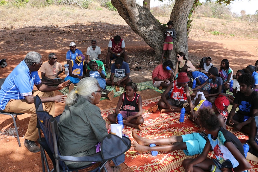 Yirrkala school students learn about country from elders and rangers under a tree in Arnhem Land