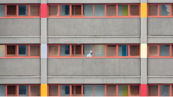 A person in a hazmat suit walking along a balcony.