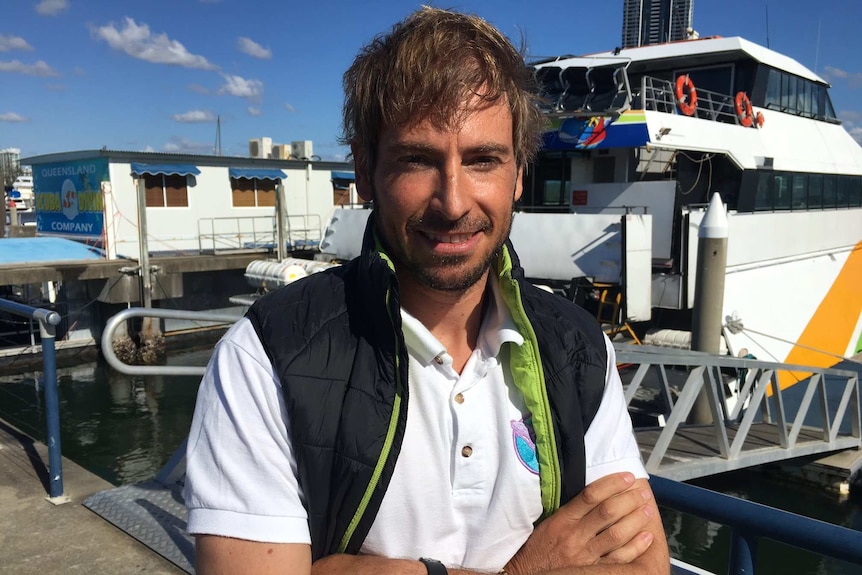 Dr Jan-Olaf Meynecke of Griffith University in front of boats in a harbour.