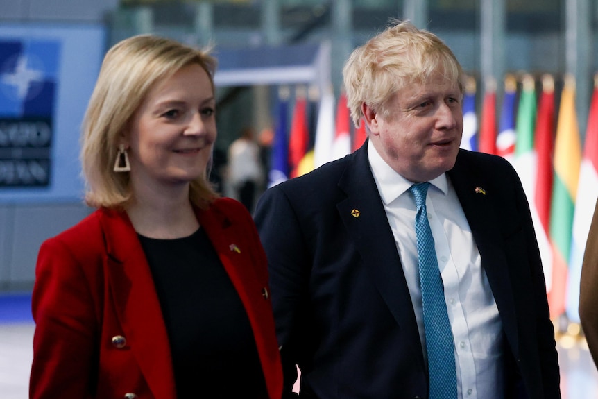 Boris Johnson walks with Liz Truss.