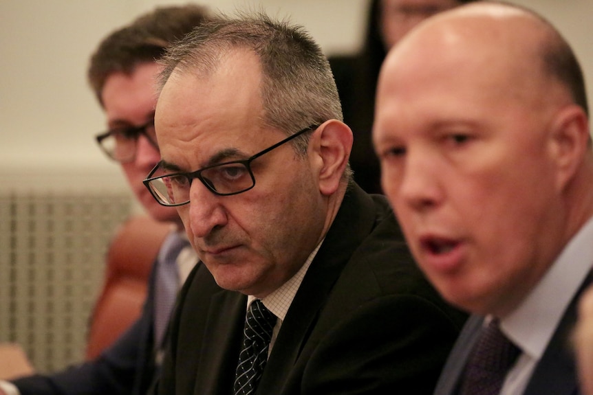 Mike Pezzullo listens as Peter Dutton talks