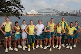 A group of Australian athletes stand in Olympic uniforms with Sydney Harbour and the Harbour Bridge behind them.