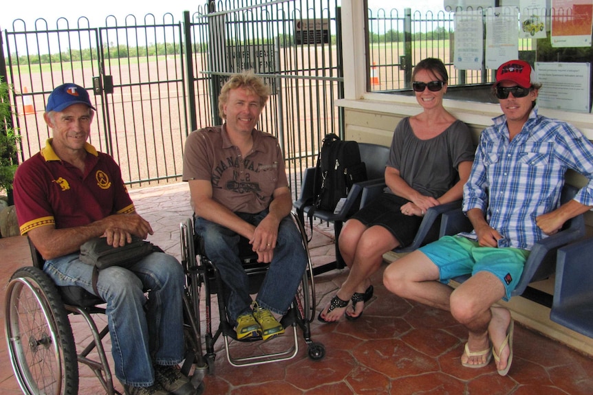 Four people, two in wheelchairs, at an outback Queensland airport.