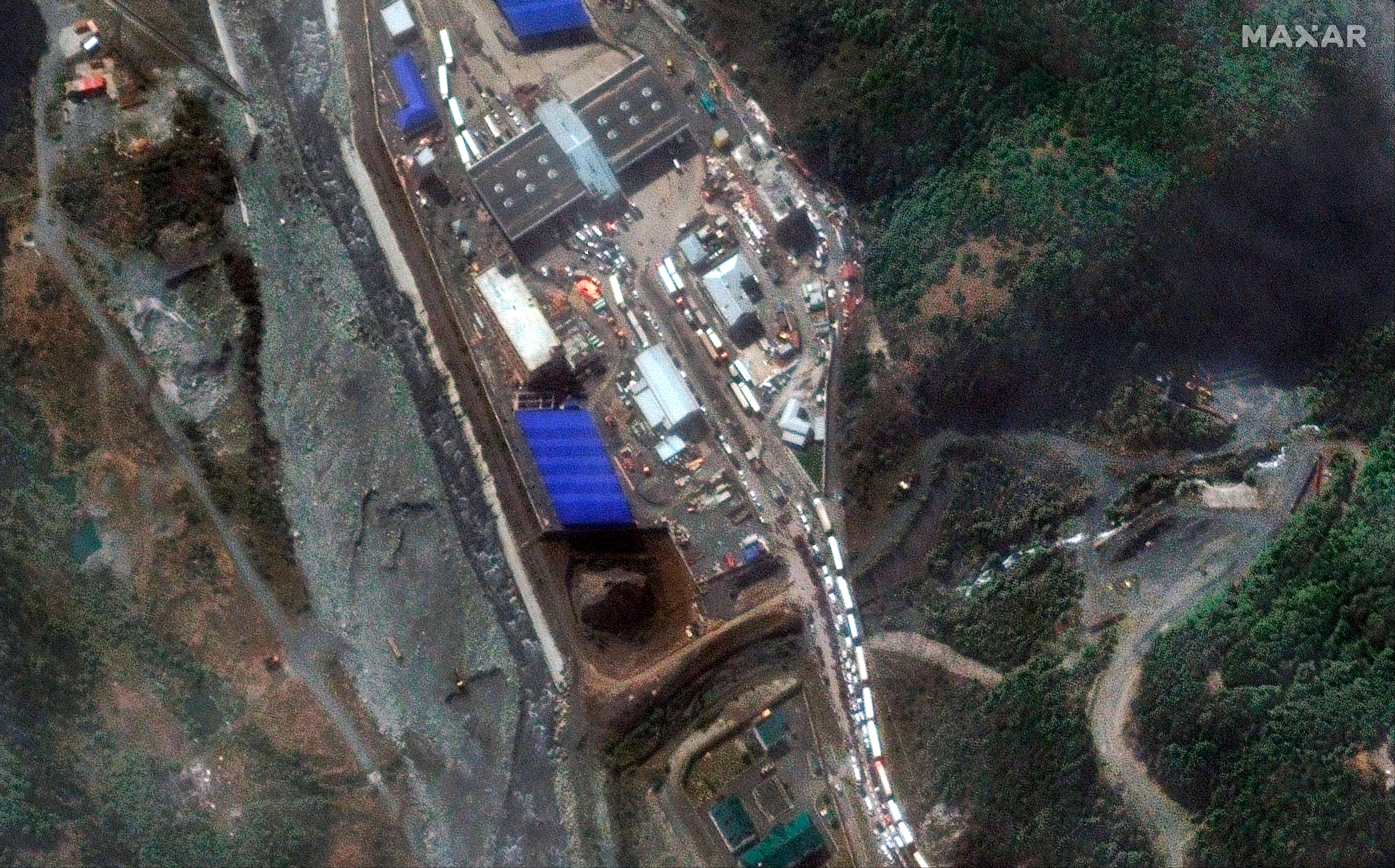 a queue of cars at a border crossing checkpoint between russia and georgia