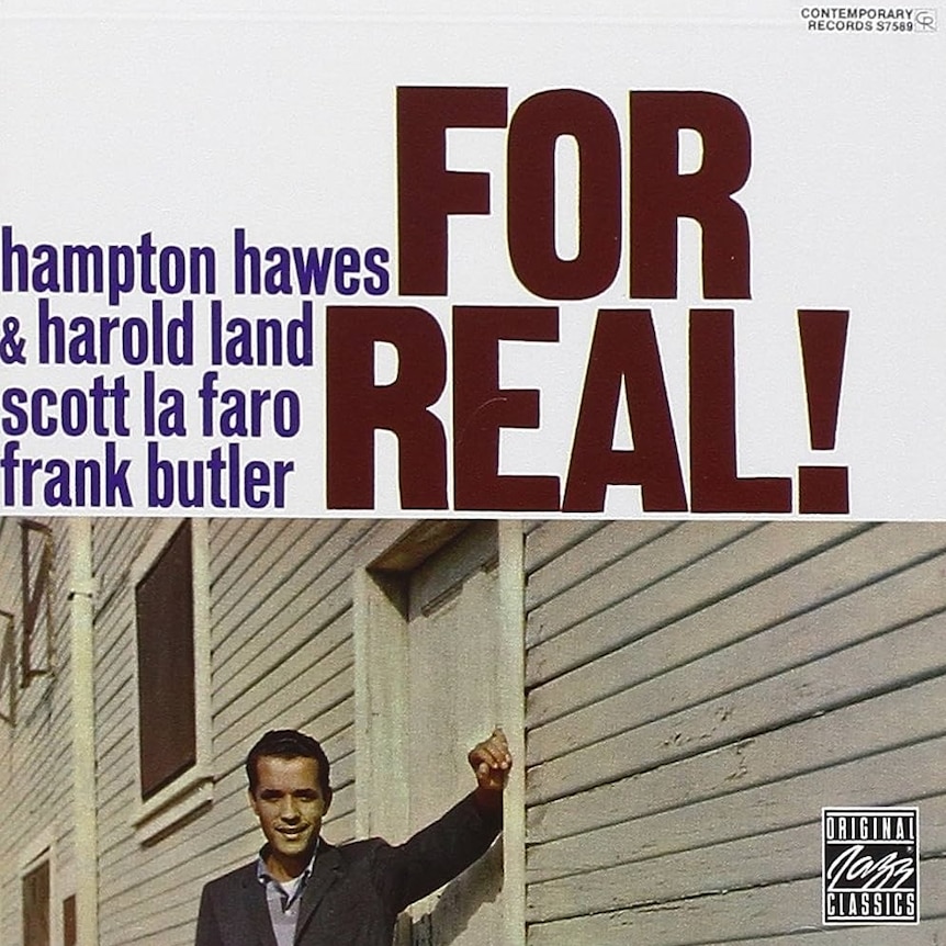 A young Hampton Hawes leans against a wooden building