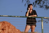 A photo of Melbourne woman Anna McDermott leaning on a railing at Nightcliff, looking out to sea.