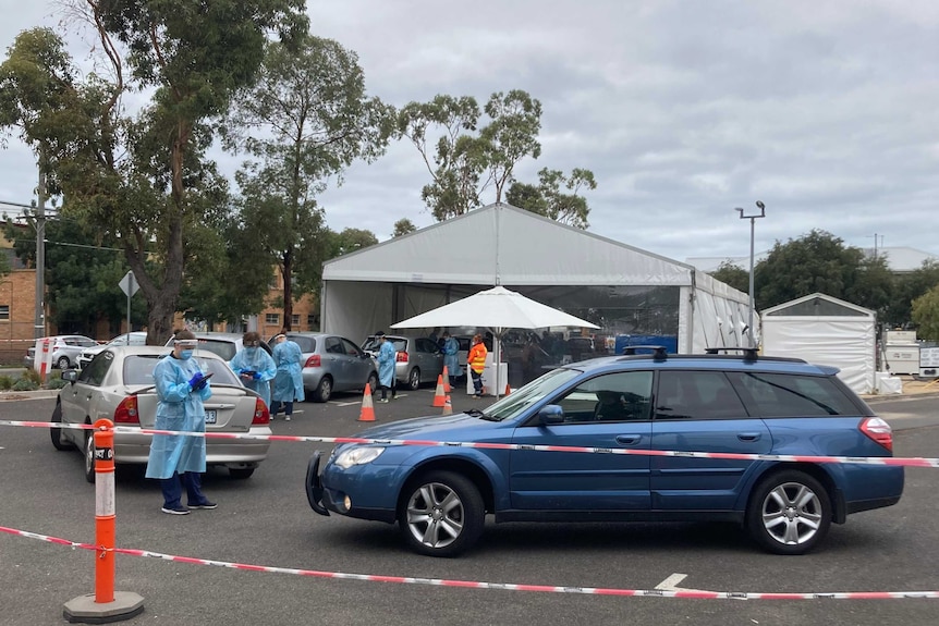 An outdoor coronavirus testing site with cars queuing up.