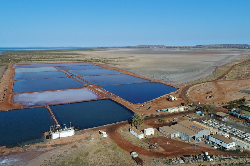 An aerial photo lookin at salt ponds and construction beneath a blue sky 