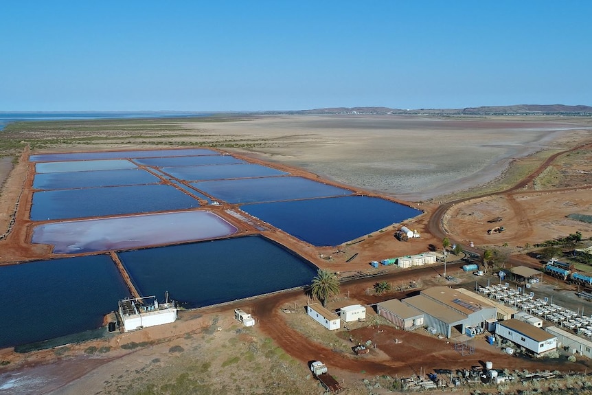 An aerial photo lookin at salt ponds and construction beneath a blue sky 