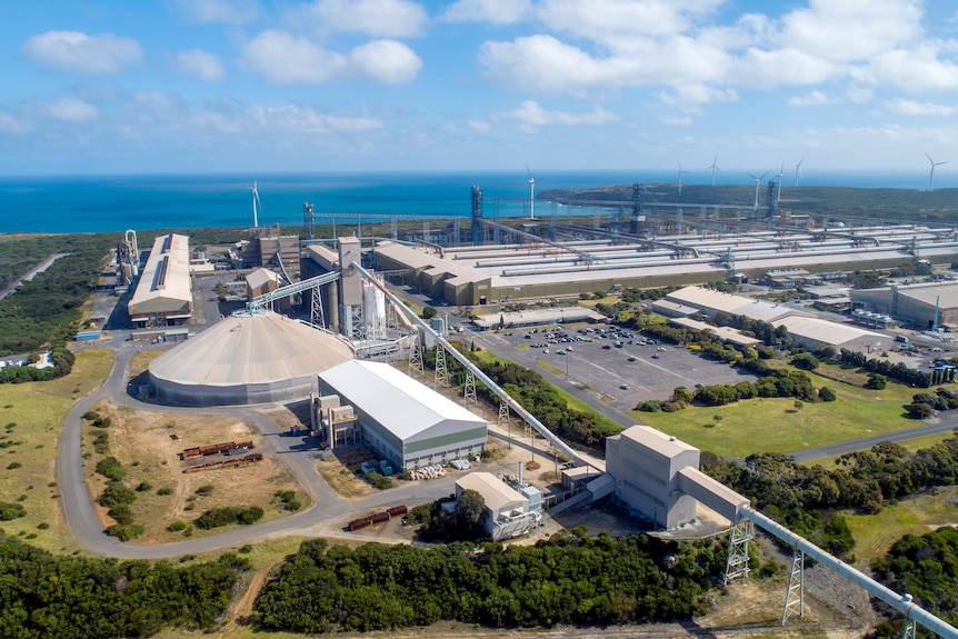 An aerial shot of an aluminium smelting plant, with the coastline on the horizon