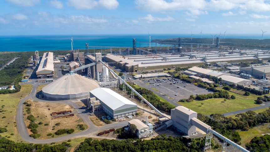 An aerial shot of an aluminium smelting plant, with the coastline on the horizon.