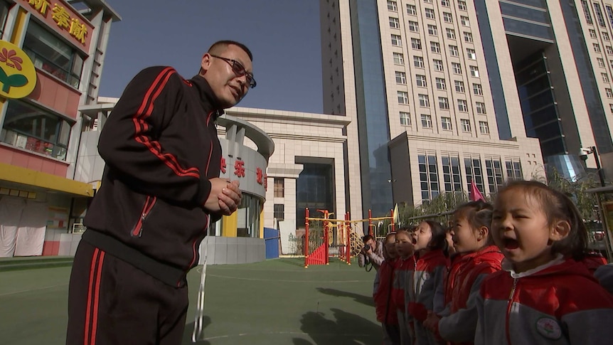 Junior development coach Ding Changbao introduces soccer to kindergarten students in Zhidan, Shaanxi province, China.