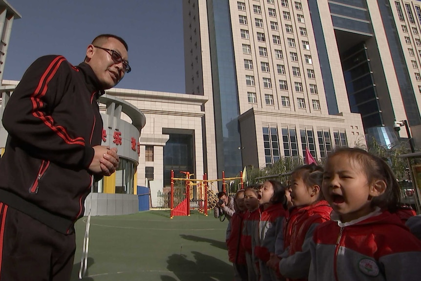 Junior development coach Ding Changbao introduces soccer to kindergarten students in Zhidan, Shaanxi province, China.