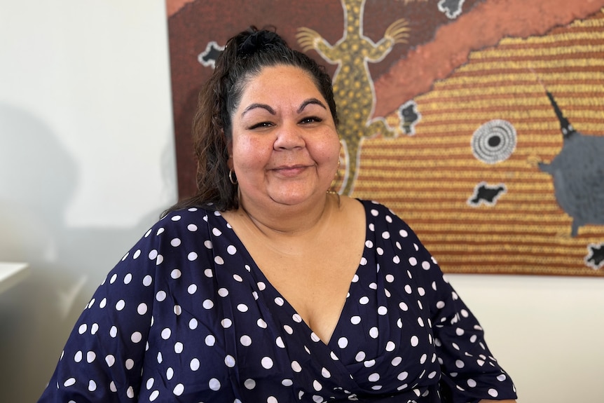 an aboriginal woman wearing a spotty dress.
