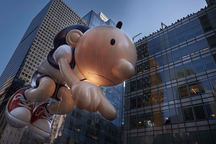 People watch from the rooftop as the Diary of a Wimpy Kid balloon moves through Sixth Avenue