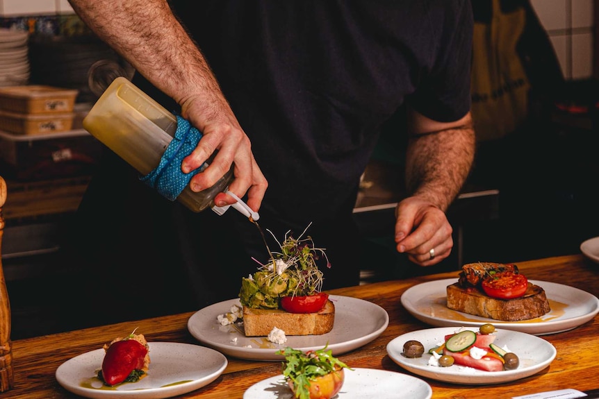 Chef in black preparing gourmet dishes