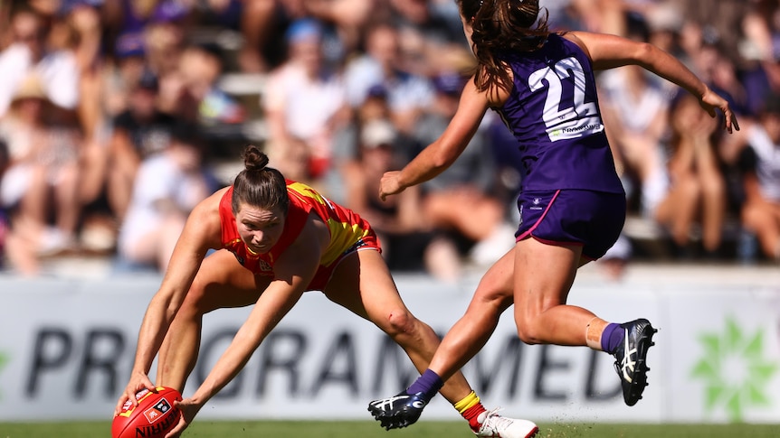 Jade Pregelj bends down to pick up the football during an AFLW match against Fremantle