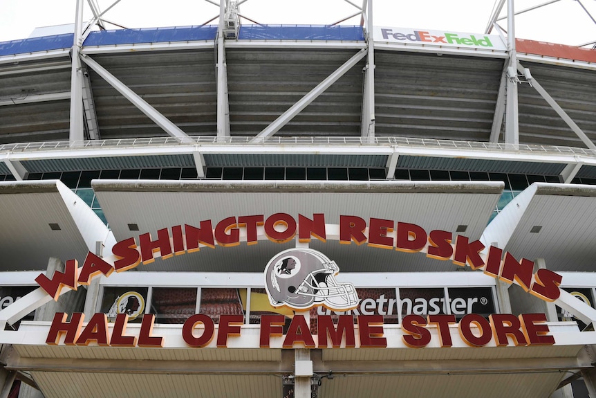 A sign for the Washington Redskins NFL team, including helmet design are outside the team stadium.