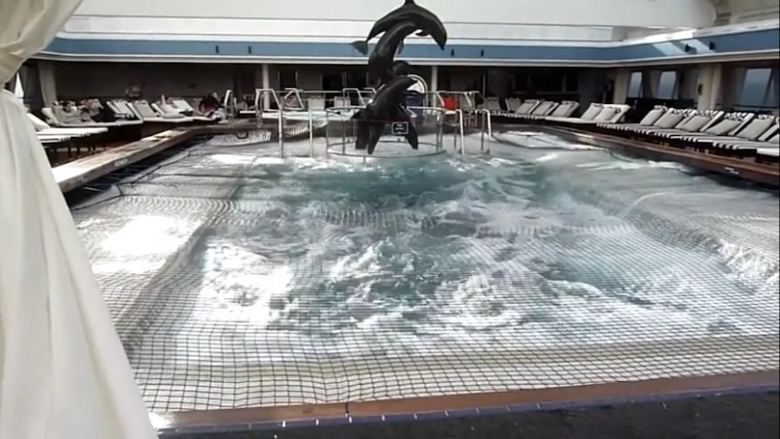 Still of cruise pool with suspended dolphin statues above.