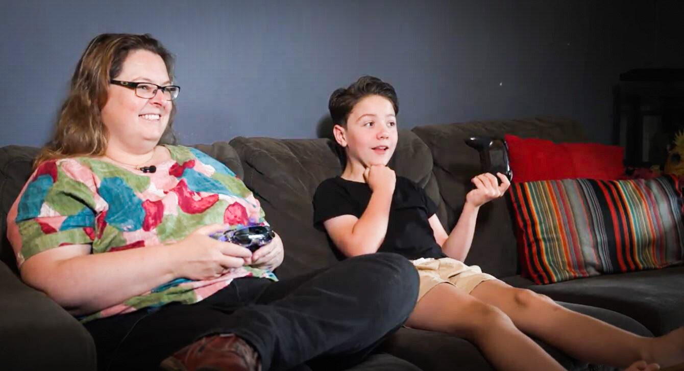 Mum Emma and son Julian gaming together on the couch.