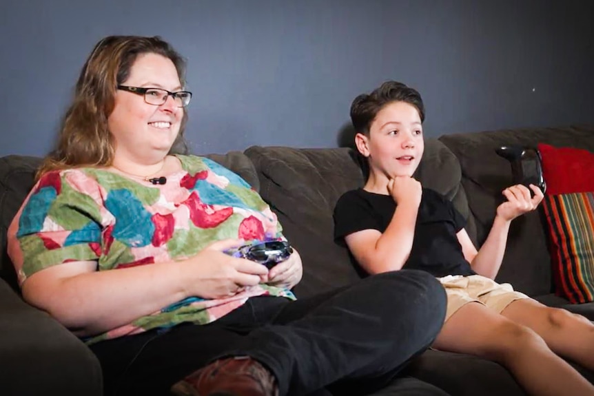 Mum Emma and son Julian gaming together on the couch.