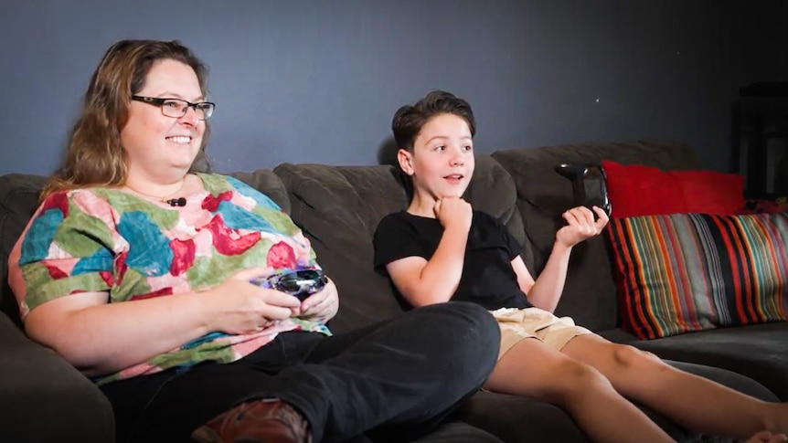 Mum Emma and son Julian gaming together on the couch.